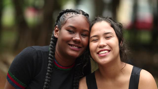 不同的女友一起对着镜头微笑。种族多样性的女性视频素材