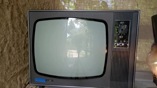 一个拿着煤油灯的男人打开了一台老式的电视视频素材