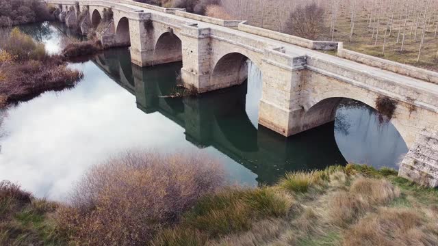 西班牙布尔戈斯省历史村庄，皮苏加河上一座中世纪石桥的鸟瞰图。高质量4k镜头视频素材