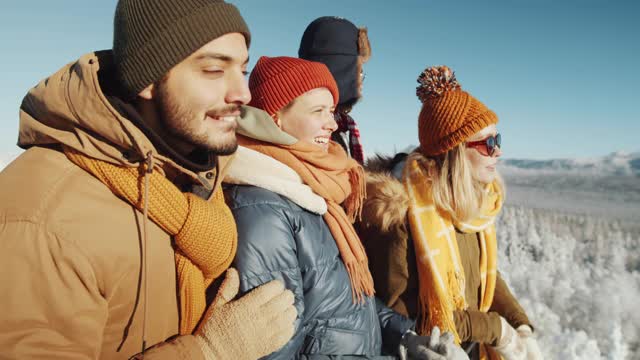年轻的徒步旅行者在冬天欣赏山上的景色视频下载