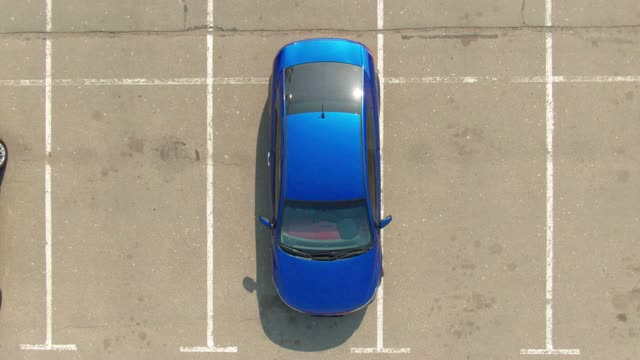 顶视图蓝色汽车驶出商场的停车场视频下载