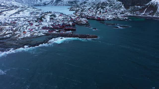 渔村A、Rorbu、海和山的冬天。Moskenes,罗弗敦群岛。挪威的风景。鸟瞰图。无人机向前飞，向上倾斜。揭示拍摄视频素材