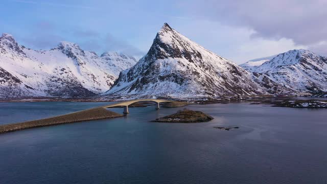 弗雷德旺桥，卡和沃兰斯坦德山在冬季日落。Flakstadoya，罗浮敦群岛，挪威风景。鸟瞰图。无人机向前和向上飞行视频素材