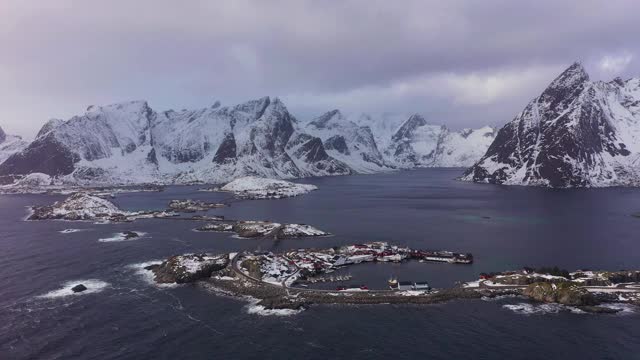 哈姆诺伊村，公路和山脉在冬天。挪威海和暴风雨的天空。摩斯基尼，罗浮敦群岛，挪威风景。鸟瞰图。无人驾驶飞机飞向后视频素材