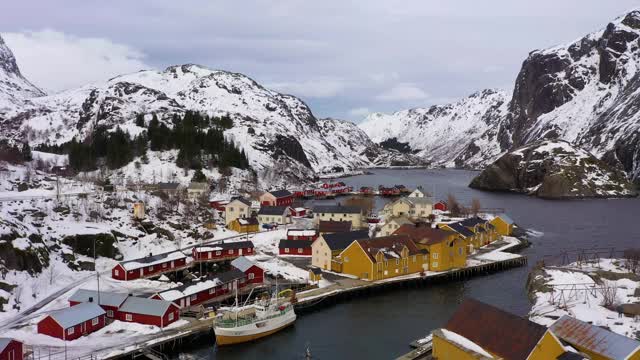 冬季的Nusfjord渔村，Rorbu, Fjord和山脉。罗弗敦群岛,挪威。鸟瞰图。无人机向后和向上飞行视频素材