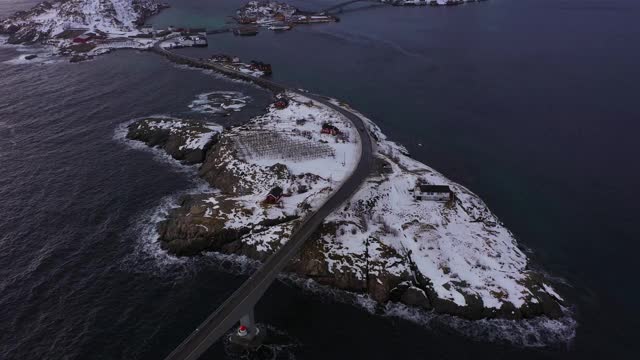哈姆诺伊村，公路和山脉在冬天。挪威海和暴风雨的天空。摩斯基尼，罗浮敦群岛，挪威风景。鸟瞰图。无人机向前飞，向上倾斜。揭示拍摄视频素材