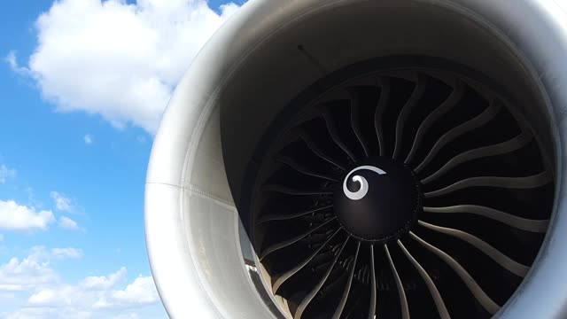 喷气涡轮发动机的飞机旋转与云和蓝天背景。视频下载