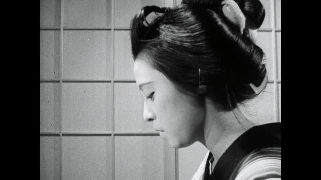 年轻的艺妓在手镜上涂唇色;1964视频下载