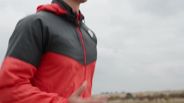 年轻健康的运动员在乡村的道路上慢跑，做热身运动来锻炼肌肉视频下载