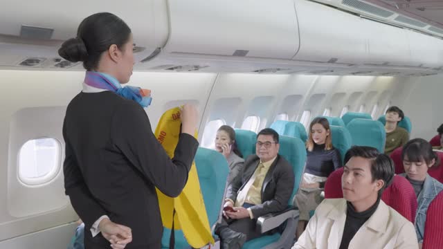 亚洲空乘人员在飞机起飞前向乘客演示安全程序。视频素材