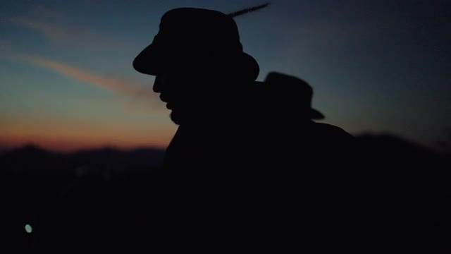 日落时分，一名男子在攀登时使用手机上的手电筒剪影视频下载