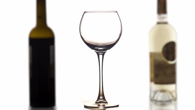红色或玫瑰红葡萄酒倒入玻璃中，酒瓶背景为白色视频下载