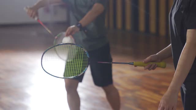 亚洲华人羽毛球运动员在羽毛球场上的手视频下载