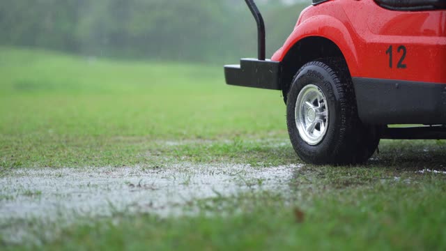 在雨天清空停在高尔夫球场的红色高尔夫球车视频下载