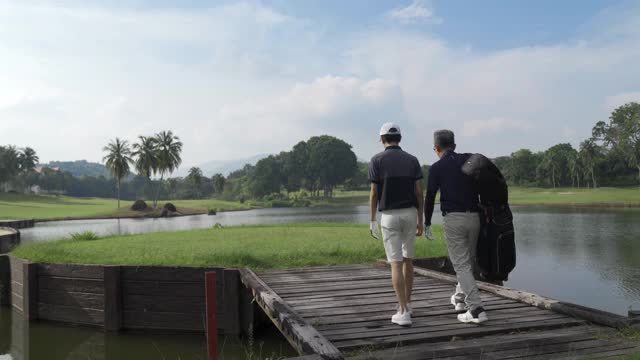 亚洲华人父子在欣赏高尔夫球场的风景视频下载