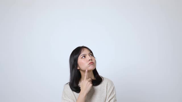 亚洲女性在孤立的白色背景和复制空间中站立和思考。视频下载