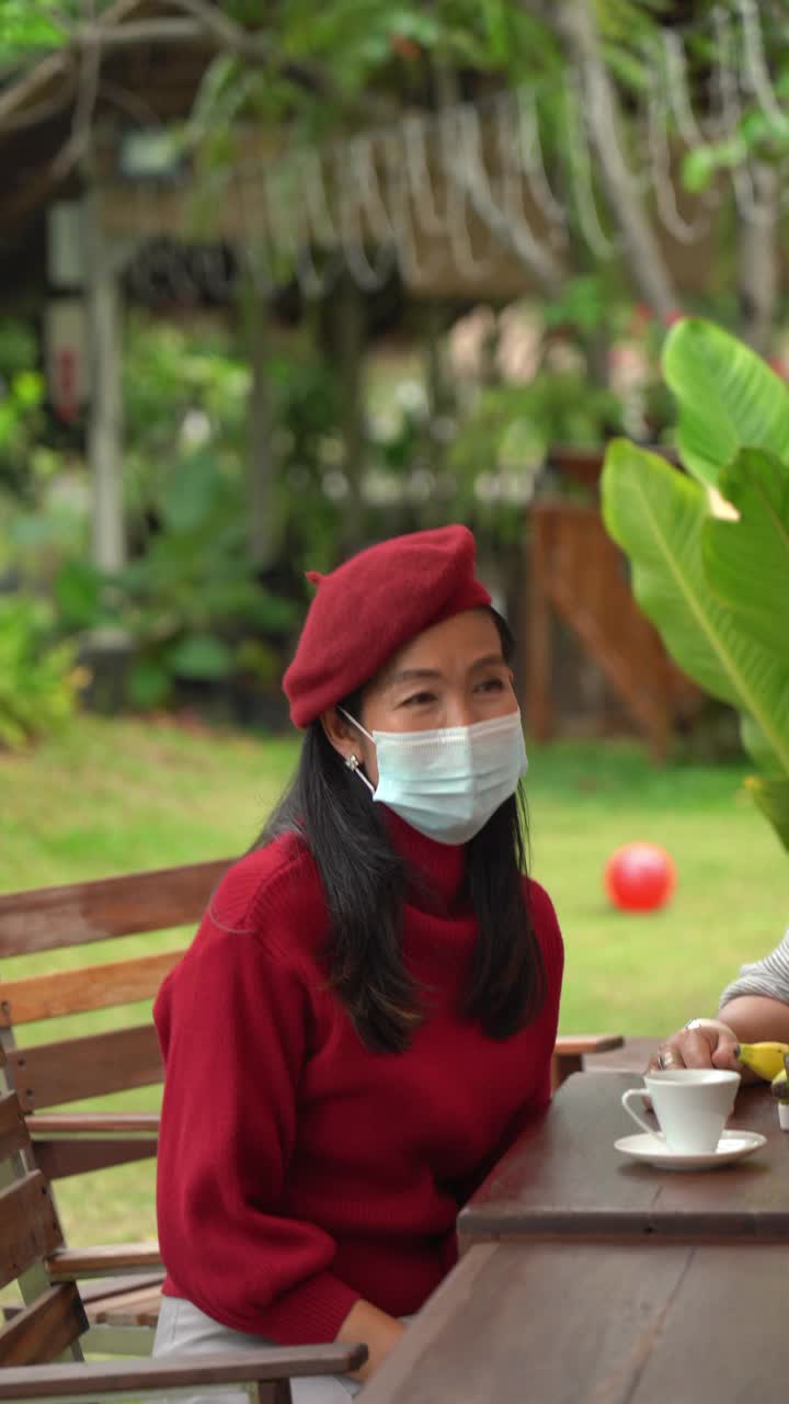 一名戴着外科口罩的老年妇女，庆祝新冠肺炎期间的节日，垂直格式视频视频下载