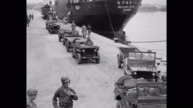 当起重机将吉普车装载到船上时，士兵们在港口等待吉普车的镜头——朝鲜战争视频下载