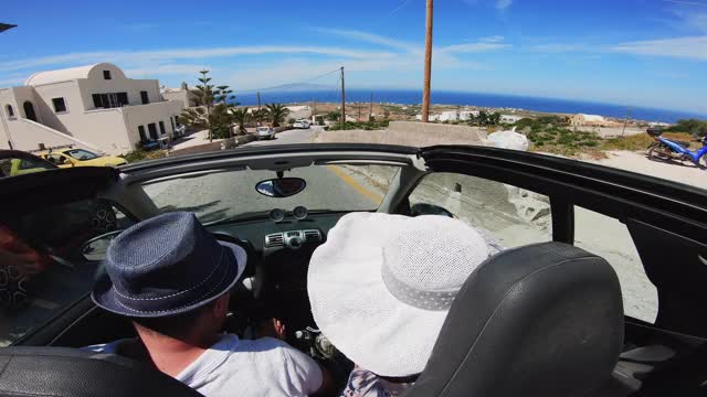 一对夫妇在希腊圣托里尼岛海滩上一起驾驶敞篷车视频素材