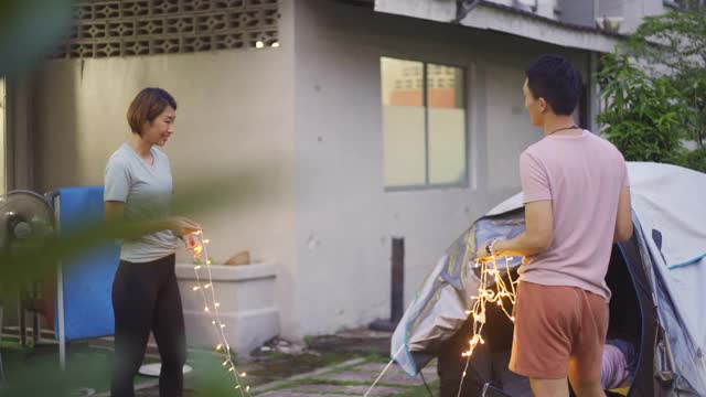 亚裔华人家庭在自家后院穿上灯饰露营，进行周末度假活动视频下载