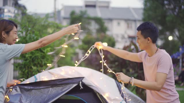 亚裔华人家庭在自家后院穿上灯饰露营，进行周末度假活动视频素材
