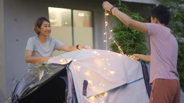 亚裔华人家庭在自家后院穿上灯饰露营，进行周末度假活动视频素材