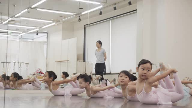穿着紧身衣的亚洲儿童和亚洲女教练正在工作室里上芭蕾课视频素材