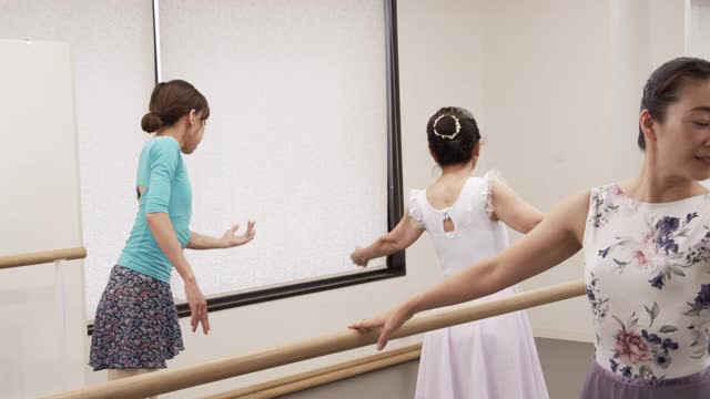 亚洲女高年级正在接受芭蕾课的亚洲女教练与芭蕾课吧。视频素材