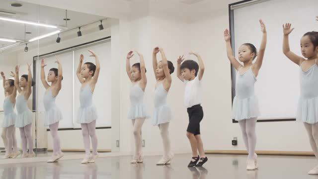 亚洲的男女儿童芭蕾舞学生在演播室的镜子前排队视频素材