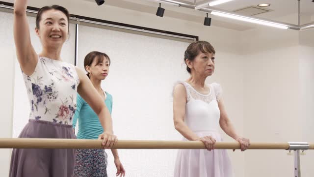 亚洲女高年级正在接受芭蕾课的亚洲女教练与芭蕾课吧。视频素材