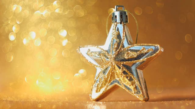 星星形状的圣诞装饰品与许多金色的散景球在背景视频素材