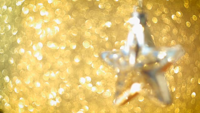 多莉。星星形状的圣诞装饰品与许多金色的散景球在背景视频素材