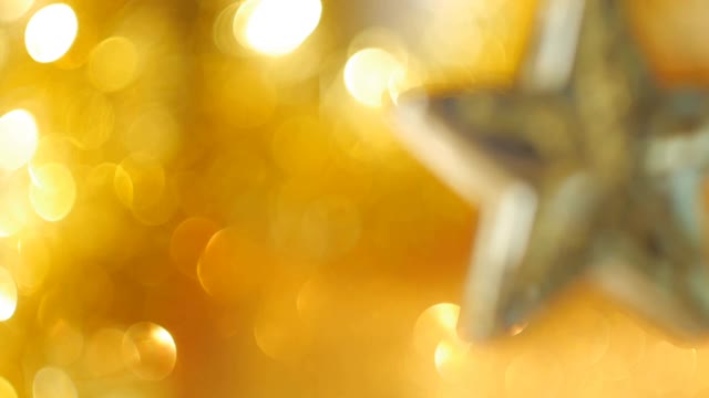 多莉。星星形状的圣诞装饰品与许多金色的散景球在背景视频素材