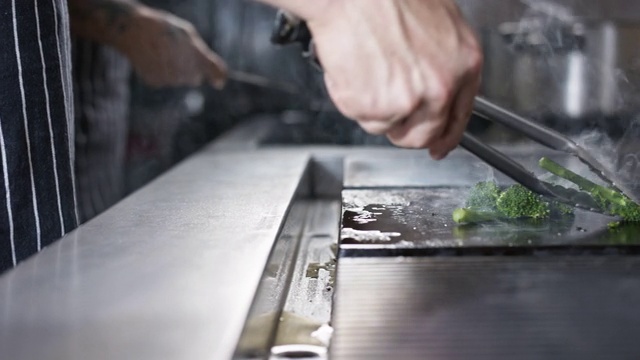 厨师用舌头把花椰菜翻过来放在热盘子上视频下载
