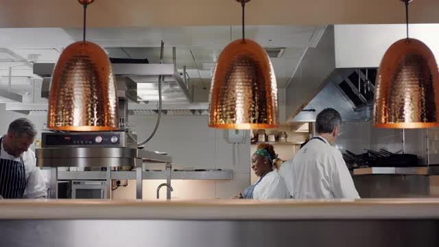 四个厨师在商业厨房工作视频下载
