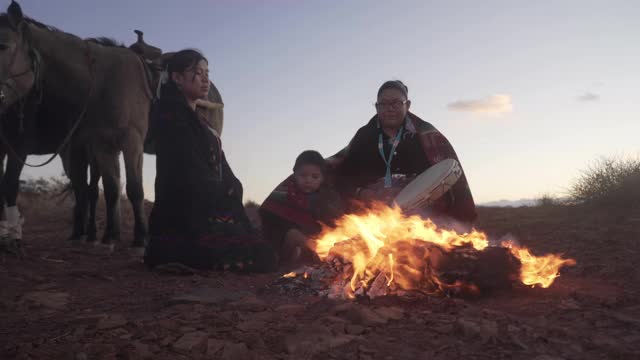 两个纳瓦霍妇女和小孩围绕着篝火和马在纪念碑谷-亚利桑那州视频下载