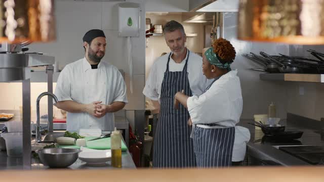 三个专业厨师在商业厨房里讨论视频素材