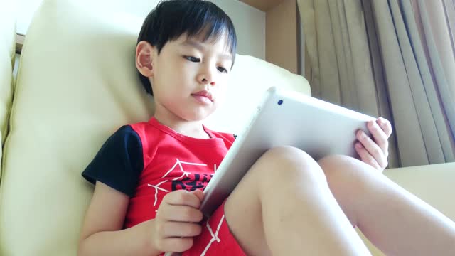 小男孩在玩数码平板电脑视频下载