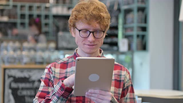 年轻的红发男人在平板电脑上失败了视频素材