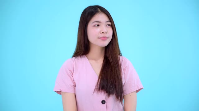 年轻的亚洲女性对孤立的蓝色背景有很好的想法视频素材