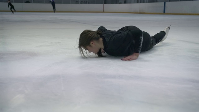 年轻女子在冰上摔倒后绝望地站了起来视频素材