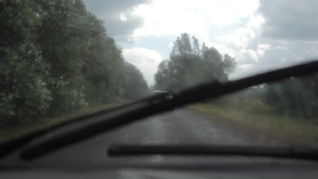 大风中，一辆汽车在乡间小路上追赶另一辆汽车。视频素材