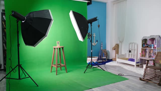 摄影或视频工作室有两个六角形工作室灯。绿色窗帘和固定椅子上的沙漏视频下载