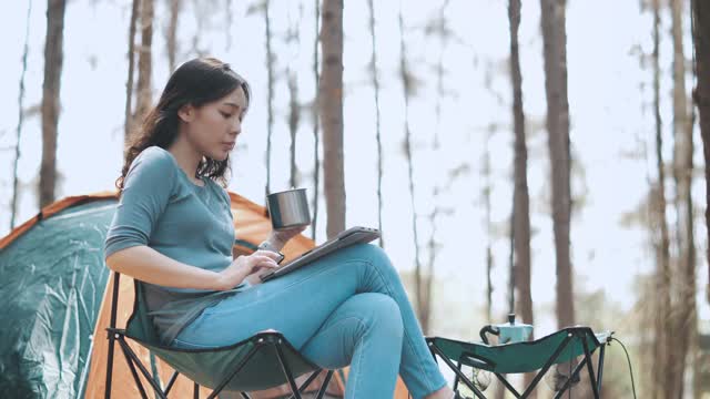 亚洲女性使用数字平板电脑露营度假视频素材