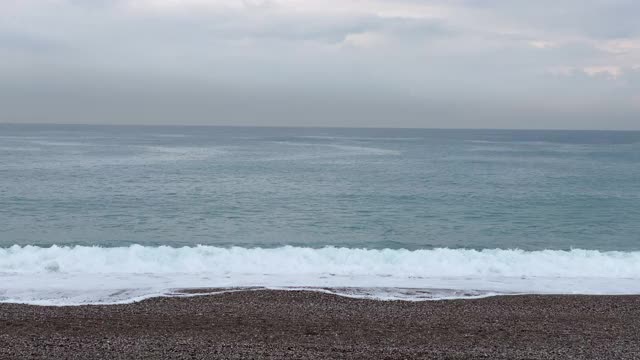 在雨天看海浪拍打海滩。视频素材