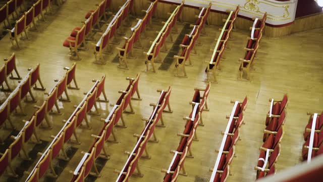 歌剧院大厅的红色天鹅绒座位被安排为流行病限制。在COVID - 19大流行隔离期间，演出前座位选择有限视频下载