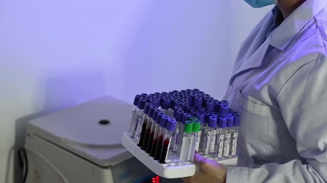 亚洲华人女性实验室助理医生在离心机上抽取小瓶血液样本视频下载