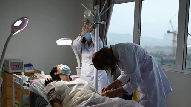 亚洲华人女医生护士从年轻女子身上取血样视频素材