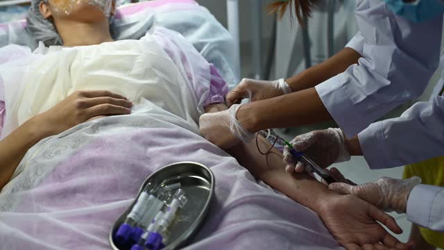 亚洲华人女医生护士从年轻女子身上取血视频素材