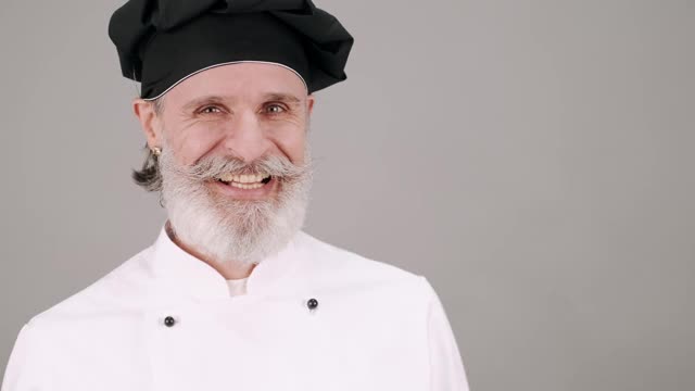在灰色背景上显示情绪的高级厨师肖像视频下载